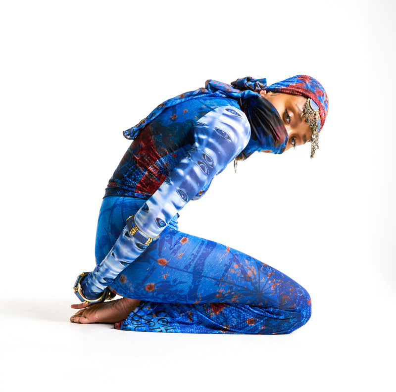 Close-up of allover eye print sleeves and tattoo motifs on the sheer Demi Top in OCEAN